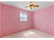 Pink bedroom with patterned walls, ceiling fan, and a sunny window at 412 N Boyd St, Winter Garden, FL 34787