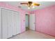 Pink bedroom with patterned walls, fan, and a closet with white doors at 412 N Boyd St, Winter Garden, FL 34787