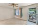 View of the living room, featuring a ceiling fan, a window with curtains, and an exterior door at 412 N Boyd St, Winter Garden, FL 34787