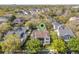 Aerial shot of a charming home nestled among trees in a vibrant neighborhood with verdant trees and well-manicured lawns at 4457 Anson Ln, Orlando, FL 32814