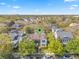 Aerial shot of a charming home nestled among trees in a vibrant neighborhood with verdant trees and well-manicured lawns at 4457 Anson Ln, Orlando, FL 32814