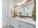 Bright bathroom vanity featuring a modern mirror, gold hardware, and white marble countertop at 4457 Anson Ln, Orlando, FL 32814