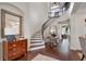 Inviting foyer with wood floors, a curved staircase, a decorative light fixture, and a stylish accent table at 4457 Anson Ln, Orlando, FL 32814