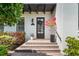 Elegant entryway with a brick staircase leading to a stylish door with dark shutters and colorful landscaping at 4457 Anson Ln, Orlando, FL 32814