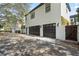 The home has a spacious garage with dark wood doors that complement the white exterior of the building at 4457 Anson Ln, Orlando, FL 32814