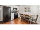 Cozy kitchen with black appliances, white cabinets, hardwood floors, and a rustic dining table at 4457 Anson Ln, Orlando, FL 32814