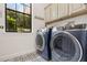 Well-equipped laundry room featuring modern appliances, cabinetry, and a stylish patterned tile floor at 4457 Anson Ln, Orlando, FL 32814