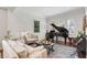 Bright living room with plush seating, a grand piano, and natural light from the windows at 4457 Anson Ln, Orlando, FL 32814