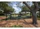 Community playground with swings and climbing structures, surrounded by lush trees providing shade and natural beauty at 4457 Anson Ln, Orlando, FL 32814