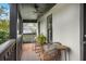 Inviting porch with a fan, black railing, and a cozy seating area for outdoor enjoyment at 4457 Anson Ln, Orlando, FL 32814