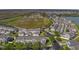 An aerial view of a neighborhood showcasing the townhome-style residences, green spaces, and proximity to a lake and roadways at 502 Rainbow Springs Loop, Groveland, FL 34736