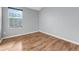 This bedroom features light gray walls, wood floors and a window with blinds at 502 Rainbow Springs Loop, Groveland, FL 34736