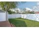 Lush green backyard enclosed by a white fence, complemented by a storage shed, and mature trees at 504 Teakwood Dr, Altamonte Springs, FL 32714