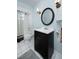 Well-lit bathroom with a tub-shower, a dark vanity, and a decorative round mirror at 504 Teakwood Dr, Altamonte Springs, FL 32714