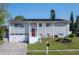 Inviting two-story home with a bright red front door, solar panels, well-kept lawn, and attached garage at 504 Teakwood Dr, Altamonte Springs, FL 32714