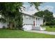 Side view of home with an attached garage, red door and lush landscaping on a large lot at 504 Teakwood Dr, Altamonte Springs, FL 32714