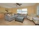 Spacious living room features large window, grey sofa and patterned arm chair at 504 Teakwood Dr, Altamonte Springs, FL 32714