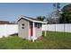 Charming, neutral backyard storage shed with a red door and white trim at 504 Teakwood Dr, Altamonte Springs, FL 32714