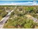 Aerial view of a landscaped property with large shade trees and a fenced yard at 505 E Plymouth Ave, Deland, FL 32724