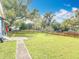 Wide backyard with a lush green lawn, mature trees, and a modern fence at 505 E Plymouth Ave, Deland, FL 32724