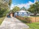 A lovely blue house is nicely landscaped with a wood fence and extra parking at 505 E Plymouth Ave, Deland, FL 32724