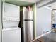 This laundry area has a stacked washer/dryer and stainless steel refrigerator at 505 E Plymouth Ave, Deland, FL 32724