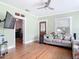 Light-filled living room features hardwood floors, a ceiling fan, and a comfortable sofa at 505 E Plymouth Ave, Deland, FL 32724