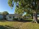 Charming home with newly landscaped front yard with green grass and a large tree at 508 W Crescent Dr, Lakeland, FL 33805