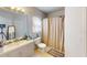 Well-lit bathroom featuring a large mirror, vanity, shower, and tile flooring at 5132 Luna Negra Dr, Orlando, FL 32811