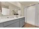 Bright bathroom with double sinks, gray cabinetry, and a walk-in shower at 5233 Marshelder St, Apopka, FL 32712