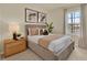 Comfortable bedroom with a neutral color scheme, accent pillows, and a window with light-filtering curtains at 5233 Marshelder St, Apopka, FL 32712