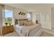 Bright bedroom featuring decorative wall art, a view to the bathroom, and serene outdoor views at 5233 Marshelder St, Apopka, FL 32712