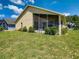 Exterior backyard featuring a well maintained lawn, landscaping, and screened patio at 527 Durango Loop St, Davenport, FL 33897