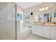 Bathroom featuring a garden tub, walk-in shower, dual vanity sinks, and neutral-toned tile at 527 Durango Loop St, Davenport, FL 33897