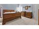 A bedroom features a large wood bed, matching dressers, light blue walls and white tile floors at 527 Durango Loop St, Davenport, FL 33897