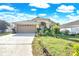 Inviting single-story home featuring a well-manicured lawn, attached garage, and beautiful landscaping at 527 Durango Loop St, Davenport, FL 33897