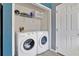 Laundry area featuring a white washer and dryer, wire shelving, and access to a storage closet at 527 Durango Loop St, Davenport, FL 33897