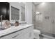 Modern bathroom with a glass shower, gray tiling, granite countertop, and white cabinets at 6030 Greatwater Dr, Windermere, FL 34786