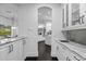 Well-lit butler pantry with white cabinets and dark wood floors throughout at 6030 Greatwater Dr, Windermere, FL 34786