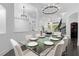 Bright open-concept dining area features a glass table, seating for eight, and elegant chandelier lighting at 6030 Greatwater Dr, Windermere, FL 34786