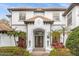 Elegant home showcasing a beautifully landscaped front entrance with a tiled roof and ornate double doors at 6030 Greatwater Dr, Windermere, FL 34786