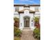 Elegant front entrance with custom wood doors and lush landscaping at 6030 Greatwater Dr, Windermere, FL 34786