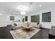 Spacious living room featuring a sectional sofa, dark floors, and a statement chandelier at 6030 Greatwater Dr, Windermere, FL 34786