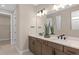 Modern bathroom featuring double vanity with sleek fixtures, neutral color palette, and tiled floors at 6799 Willow View Ave, Orlando, FL 32829