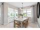 Bright dining room featuring a large table, modern light fixture and sliding glass doors to patio at 6799 Willow View Ave, Orlando, FL 32829