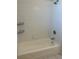 Clean bathroom featuring a tub, a shower head, white tiles, and shelving for bath products at 7109 Yacht Basin Ave # 430, Orlando, FL 32835