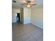 A naturally lit empty bedroom features tile flooring, a ceiling fan, and a window at 7109 Yacht Basin Ave # 430, Orlando, FL 32835