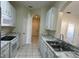 A kitchen featuring white cabinets and appliances, with a view into the entryway and other rooms at 7109 Yacht Basin Ave # 430, Orlando, FL 32835