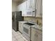 Kitchen with white cabinetry, white appliances, and light countertops next to a gray refrigerator at 7109 Yacht Basin Ave # 430, Orlando, FL 32835