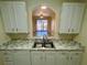 Kitchen featuring stone countertops, white cabinets and appliances, and a view into the living room at 7109 Yacht Basin Ave # 430, Orlando, FL 32835